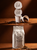 TOWS Coffee Co. coffee pods and bag on a wooden surface with coffee beans.